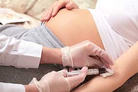 Image of a pregnant person having blood taken.
